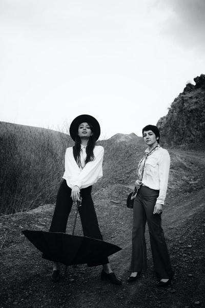 Two women standing on the grass during the day
